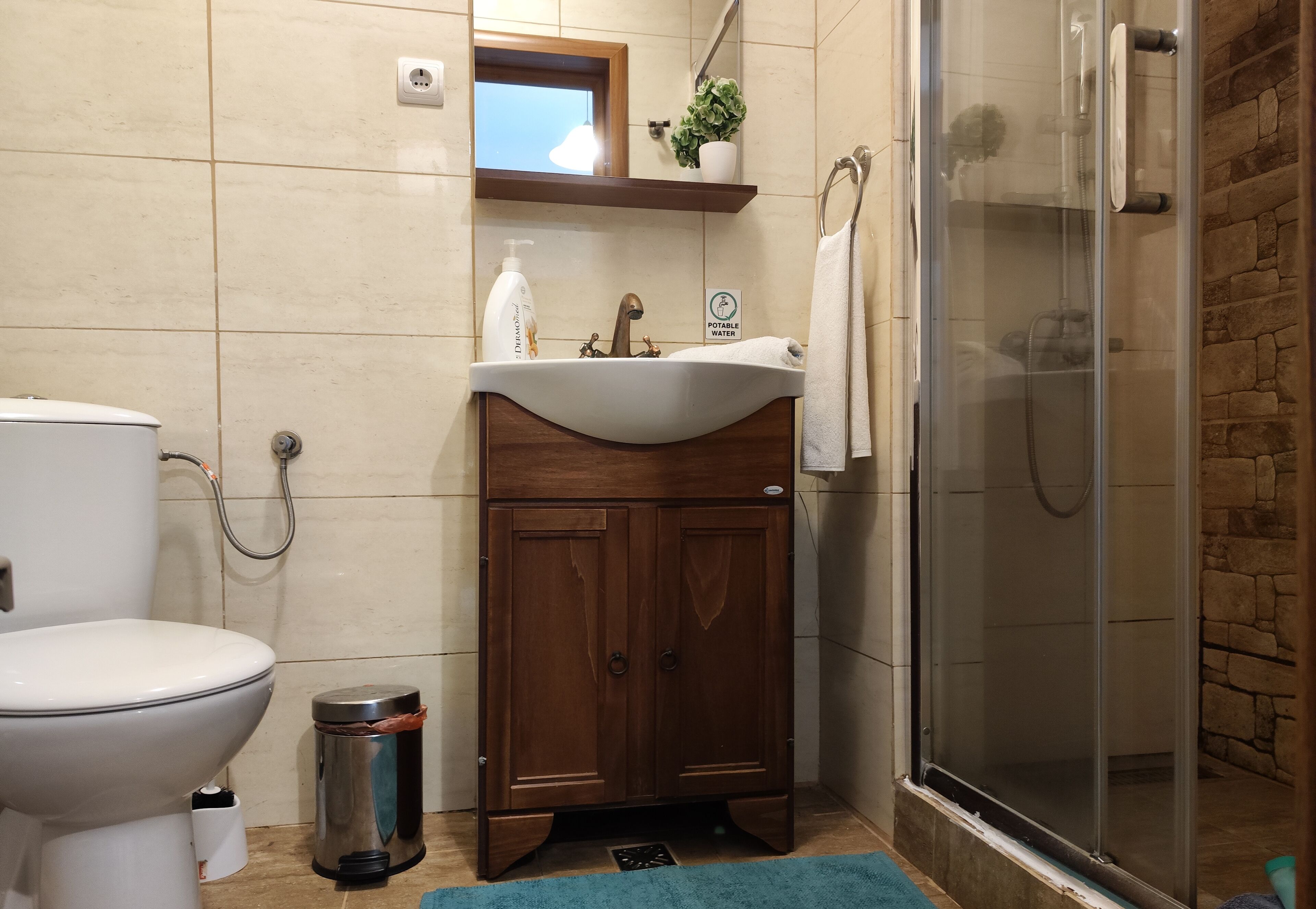 Een badkamer met toilet, wastafel en douche.
