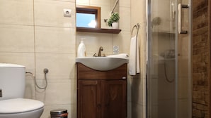 Een badkamer met toilet, wastafel en douche.