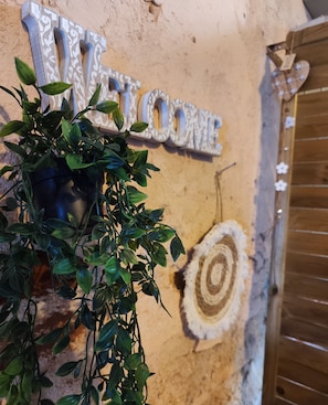 A welcome sign with a wooden door and a tree ring pattern on the wall. - Buon Studio Sibiu, near train station and Small Square Old Town (Sibiu)