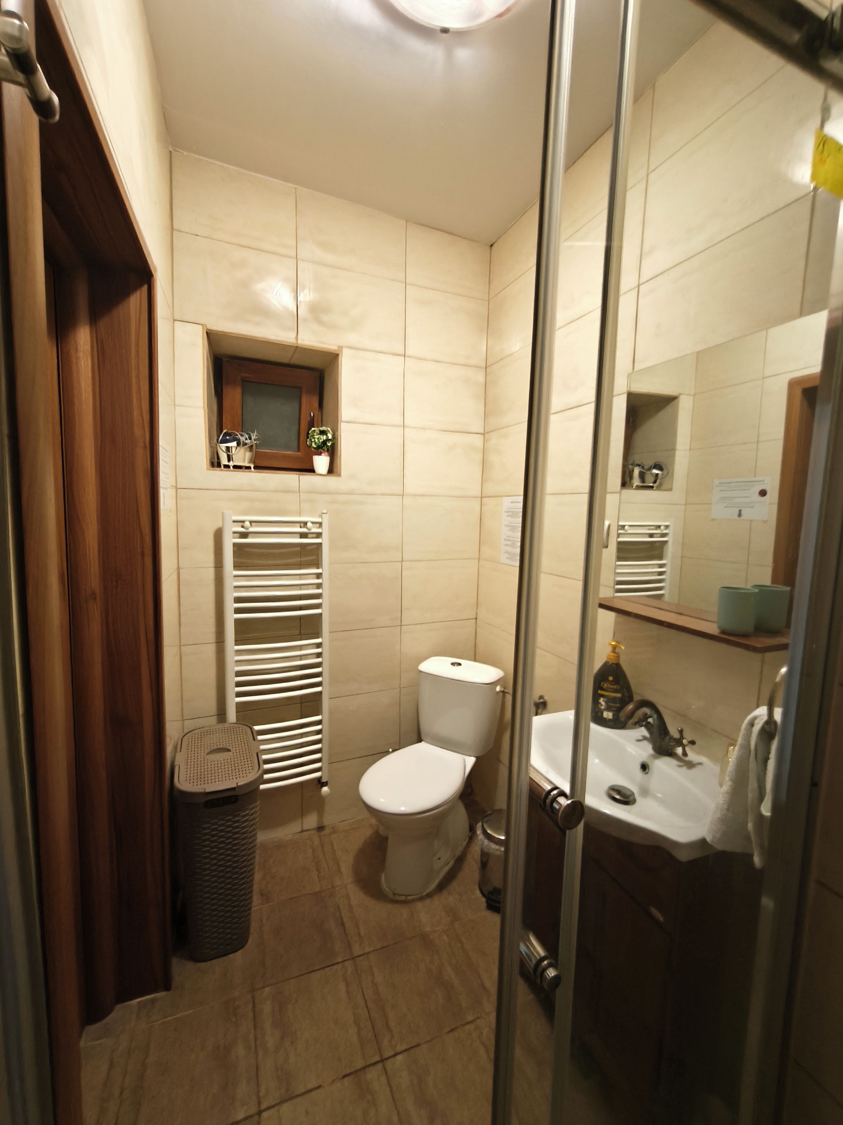 A bathroom with a toilet, sink, and a mirror.