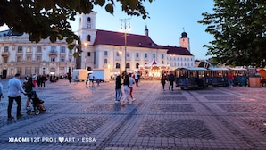 Een historisch plein met kinderafslagen, een opvallende klokkentoren en een gezellige markt.