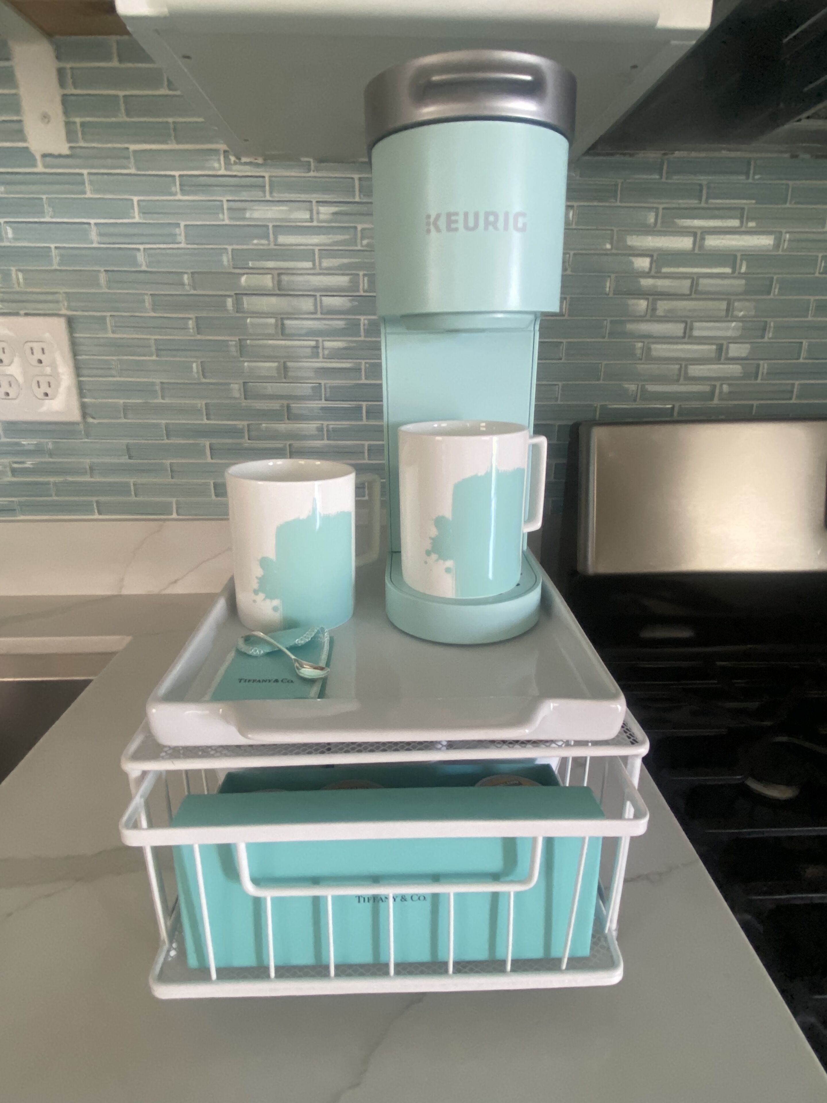 Une cuisine équipée d’une machine à café, de deux tasses et d’un plateau.