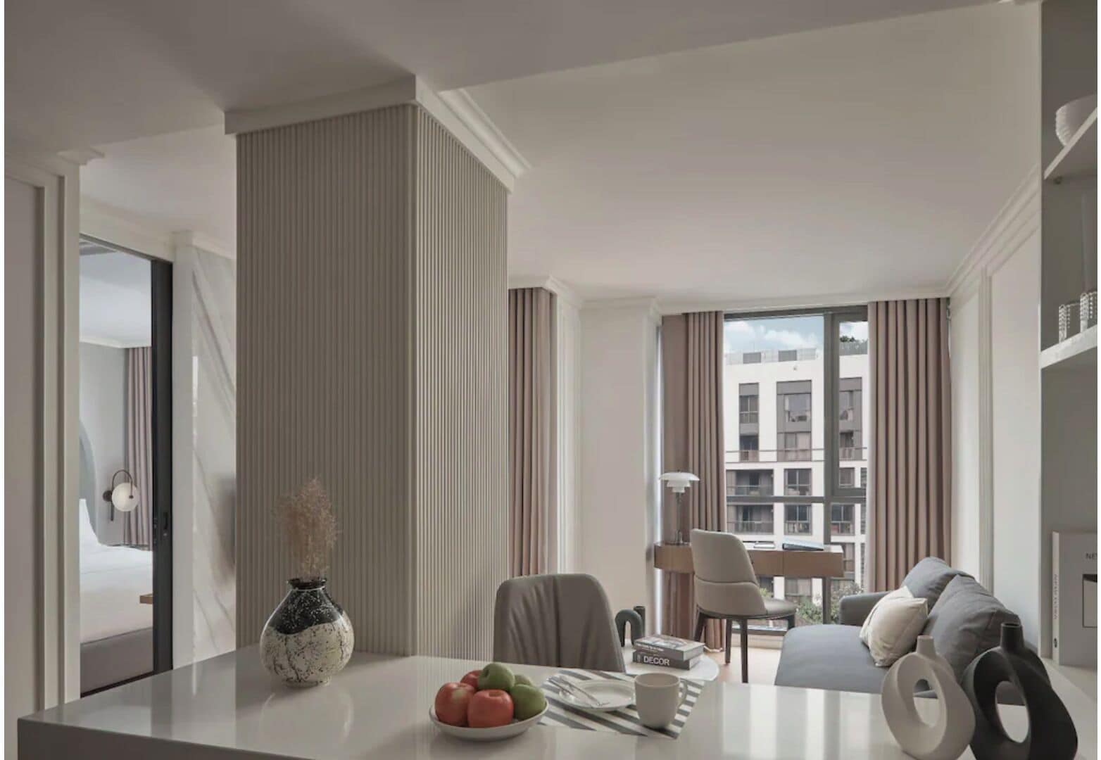 Una habitación de hotel moderna con comedor, sofá y vista a la ciudad.
