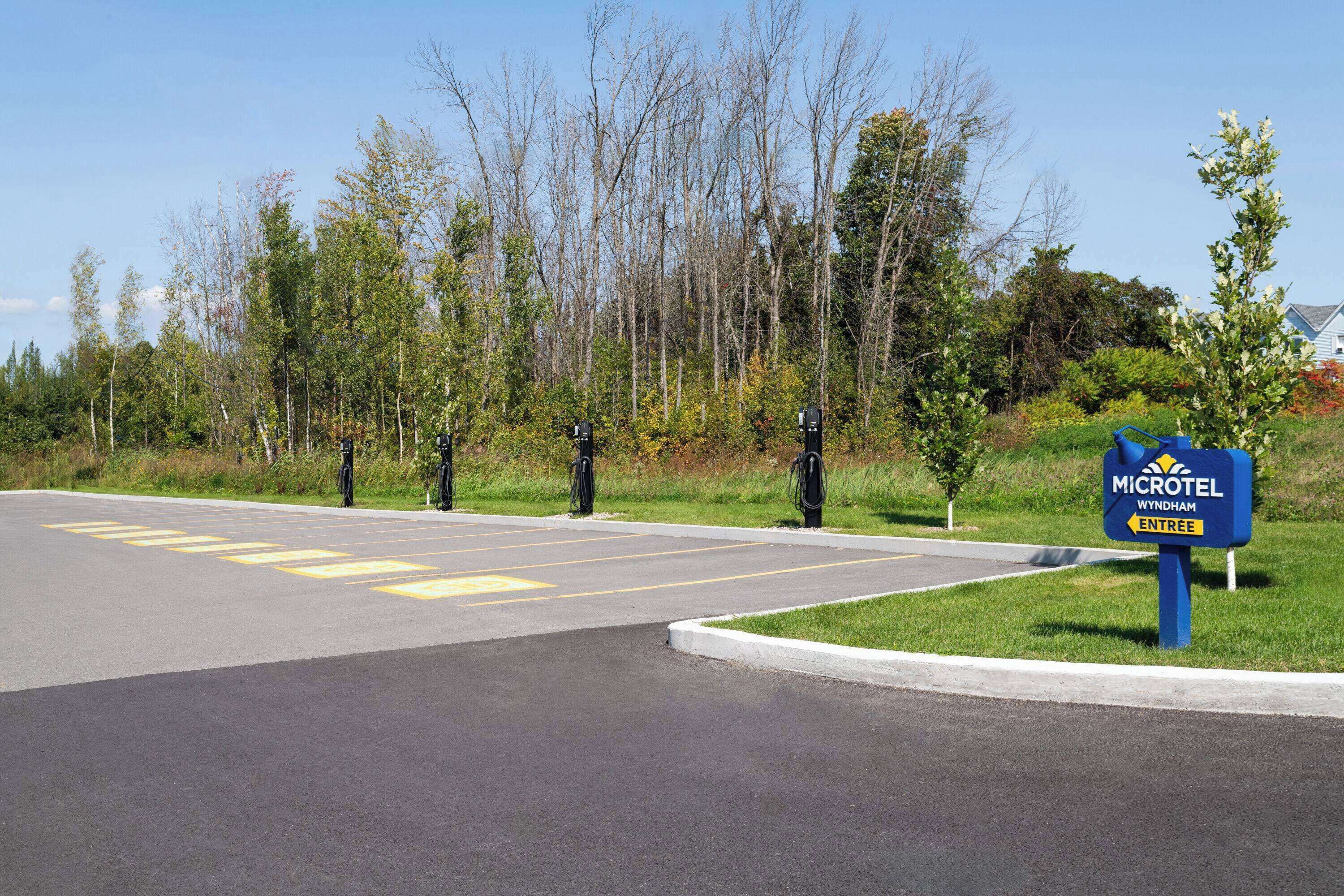 Un parking avec des places délimitées et un panneau indiquant l’entrée du Microtel Wyndham.