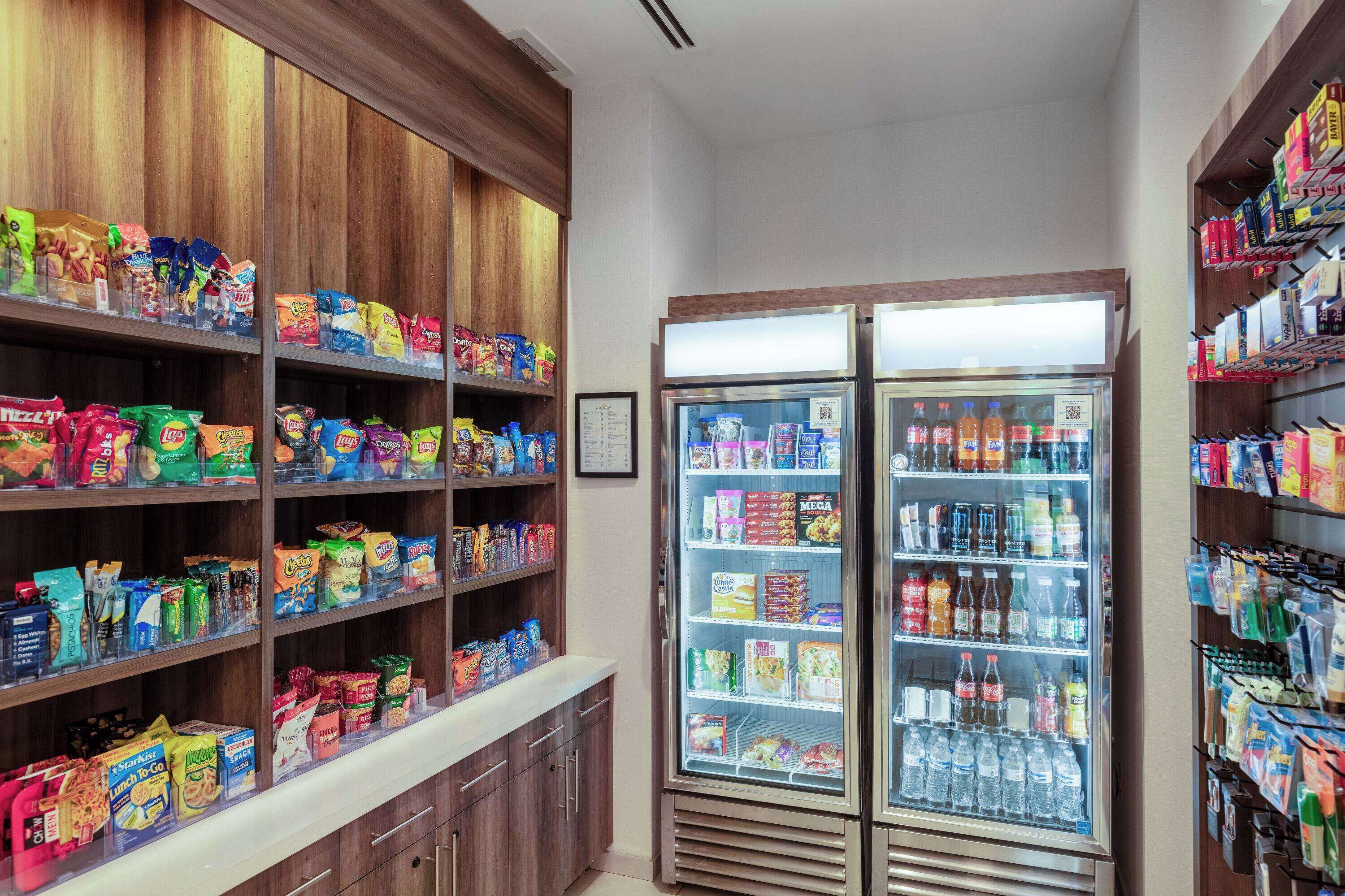A snack and beverage section with shelves stocked with various snacks and a refrigerated display case with beverages.