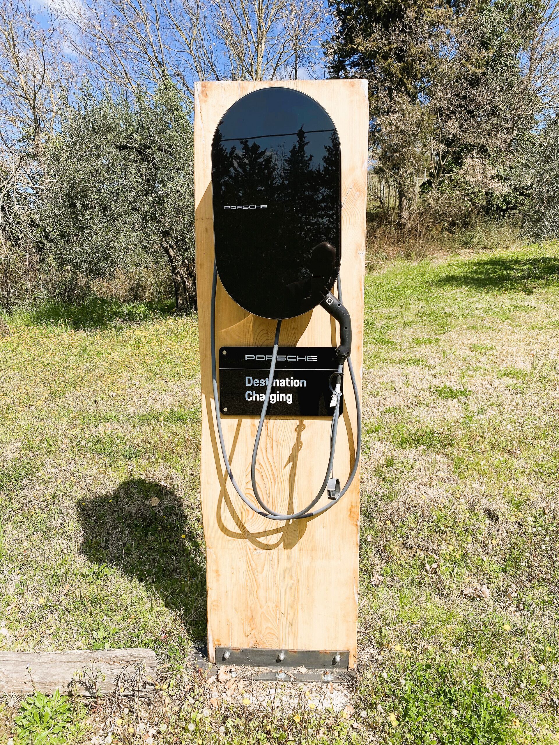 A wooden charging station with a sign indicating it is for destination charging.