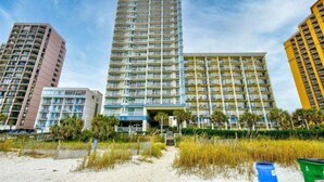 A high-rise hotel with multiple balconies, a beach view, and a modern architectural design. - Breathtaking 2BR Condo w Floor-to-Ceiling Windows Overlooking Ocean (Myrtle Beach)