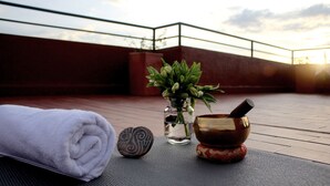 Eine Dachterrasse mit Handtuch, Stein, kleiner Pflanze in einem Glas und Holznapf mit Löffel.