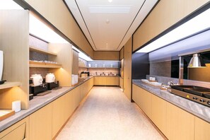 Una cocina moderna con armarios de madera, electrodomésticos de acero inoxidable y una encimera amplia.