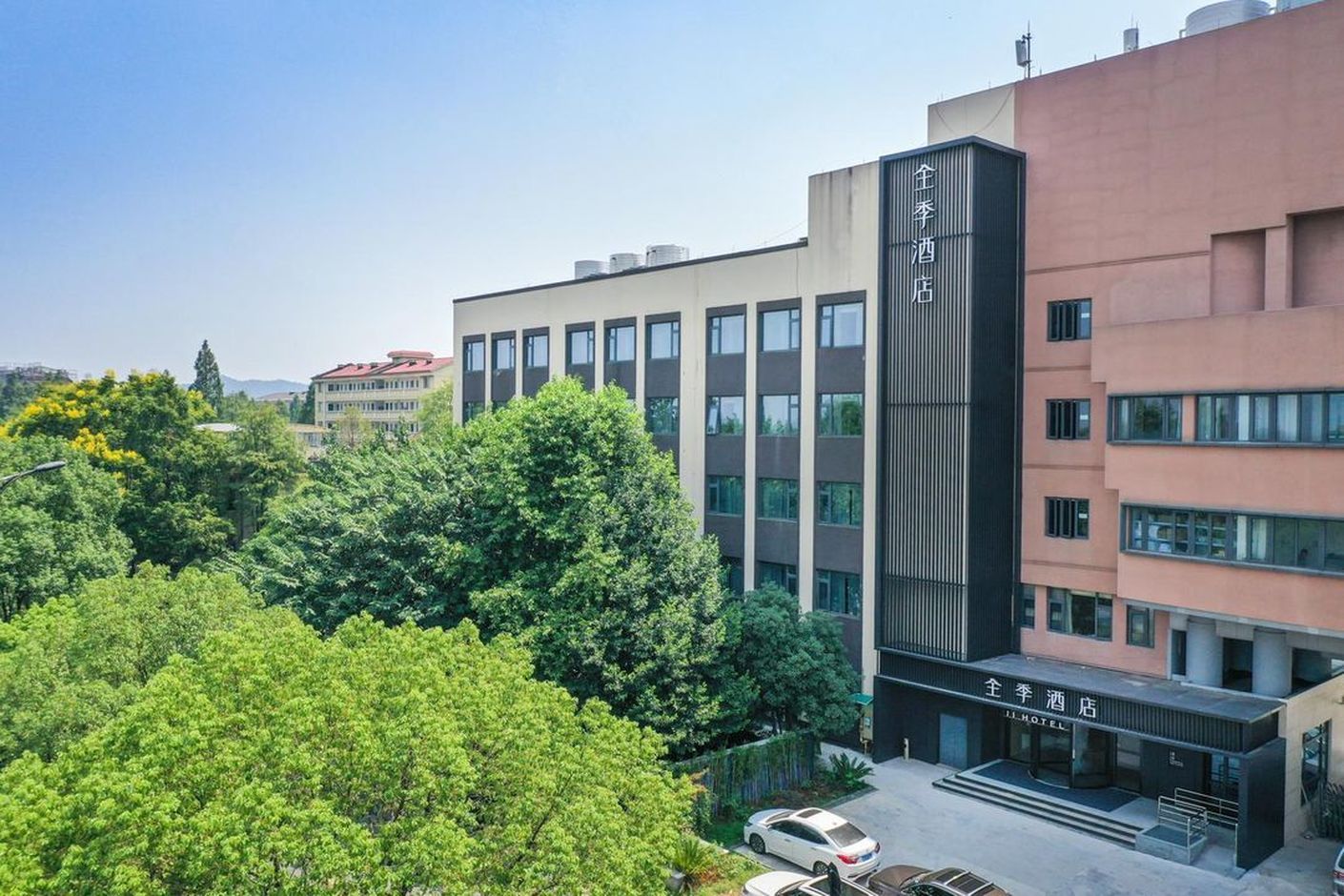 A hotel with a modern facade, multiple floors, and a parking area.