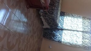 A room with a bed, a wooden cabinet, and a small table.