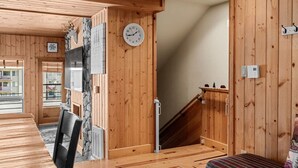 A wooden interior with a dining area, a clock, and a staircase. - Aspen Summit Retreat (Brian Head)