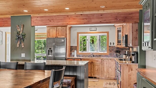 A modern kitchen with wooden cabinets, a stainless steel refrigerator, and a large island. - Aspen Summit Retreat (Brian Head)