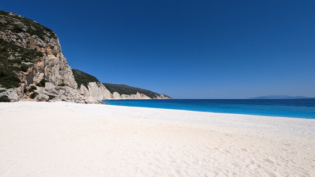 A beach with white sand and clear blue water, surrounded by rocky cliffs and a clear sky. - Stunning, Beautiful Villa. Breathtaking Sea Views. Sandy Beaches (Lourdata)