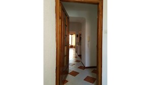 A hallway with a checkered floor pattern leading to a kitchen area. - Exceptional view + large apartment overlooking the Bay of Algiers (Wilaya d'Alger)