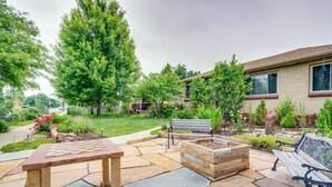 A patio with stone flooring, a fire pit, and benches. - Shared Patio & Fire Pit: Denver Apartment (Denver)