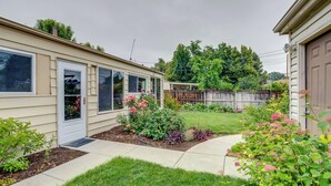 A residential property with a front yard, a wooden fence, and a garage. - Shared Patio & Fire Pit: Denver Apartment (Denver)