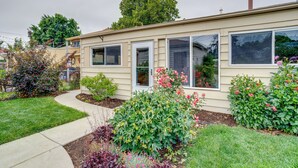 A single-story house with a front yard, a pathway leading to the entrance, and a variety of flowering plants. - Shared Patio & Fire Pit: Denver Apartment (Denver)