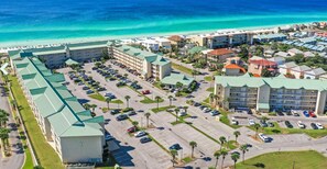 A hotel with multiple buildings, a parking lot, and a beach in the background. - Destin Stella Marina at Maravilla Pet Friendly & Beach SVC (Miramar Beach)