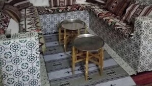 A cozy seating area with a sofa, two small tables, and patterned rugs. - Dar Naftah, la belleza del sur de Túnez, una perla (Nefta)