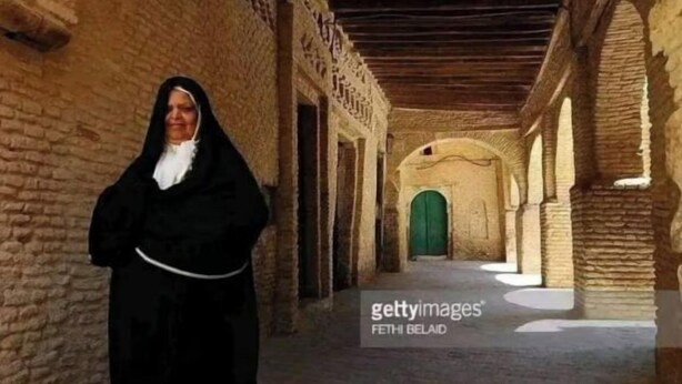 A corridor with stone walls and a wooden ceiling, leading to a green door at the end. - Dar Naftah, la belleza del sur de Túnez, una perla (Nefta)