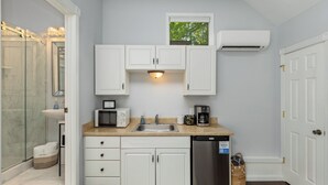 A compact kitchen with white cabinets, a microwave, a sink, and a dishwasher. - Studio in Downtown  (Haven Suites · Saugatuck) (Saugatuck)
