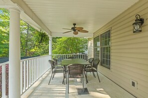 A covered porch with a table and chairs, a ceiling fan, and a view of trees. - Gorgeous 3BR, 2BA; The Perfect Home Away From Home! (Downtown Saugatuck) (Saugatuck)