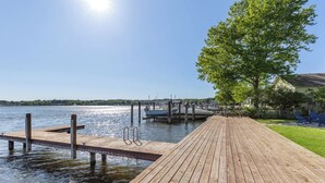 A wooden dock extending into calm water, a clear sky, and a tree-lined area. - Spacious 5BR, 3BA Waterfront Home w/Fenced Backyard & Private Boat Dock (Saugatuck)
