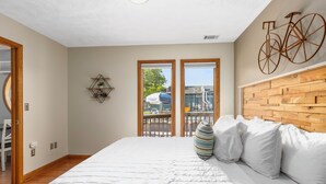 Ein Schlafzimmer mit einem großen Bett, einem Holzkopfende und einer Fahrrad-Dekoration an der Wand.