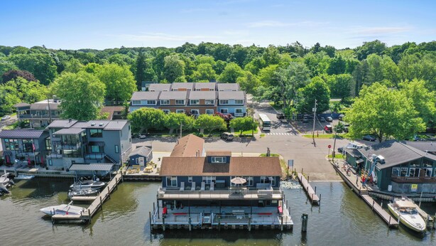Une propriété située au bord de l’eau, dotée d’un quai, de bateaux et d’un bâtiment avec une grande terrasse.