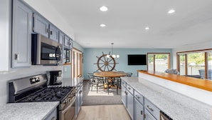 A modern kitchen with granite countertops, stainless steel appliances, and a central island.