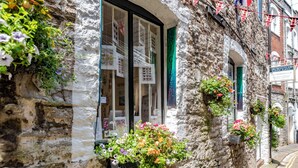 A stone building with a shop window displaying various items. - Luxury 2 bed Apartment Mount Wise Plymouth Parking (Plymouth)