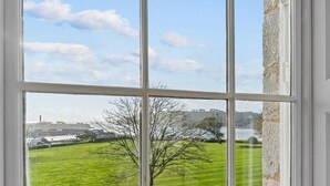 A window with a view of a green field and a distant building. - Luxury 2 bed Apartment Mount Wise Plymouth Parking (Plymouth)