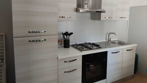 A modern kitchen with a gas stove, oven, and stainless steel sink.