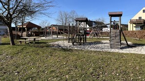 A playground with climbing structures and a picnic table.