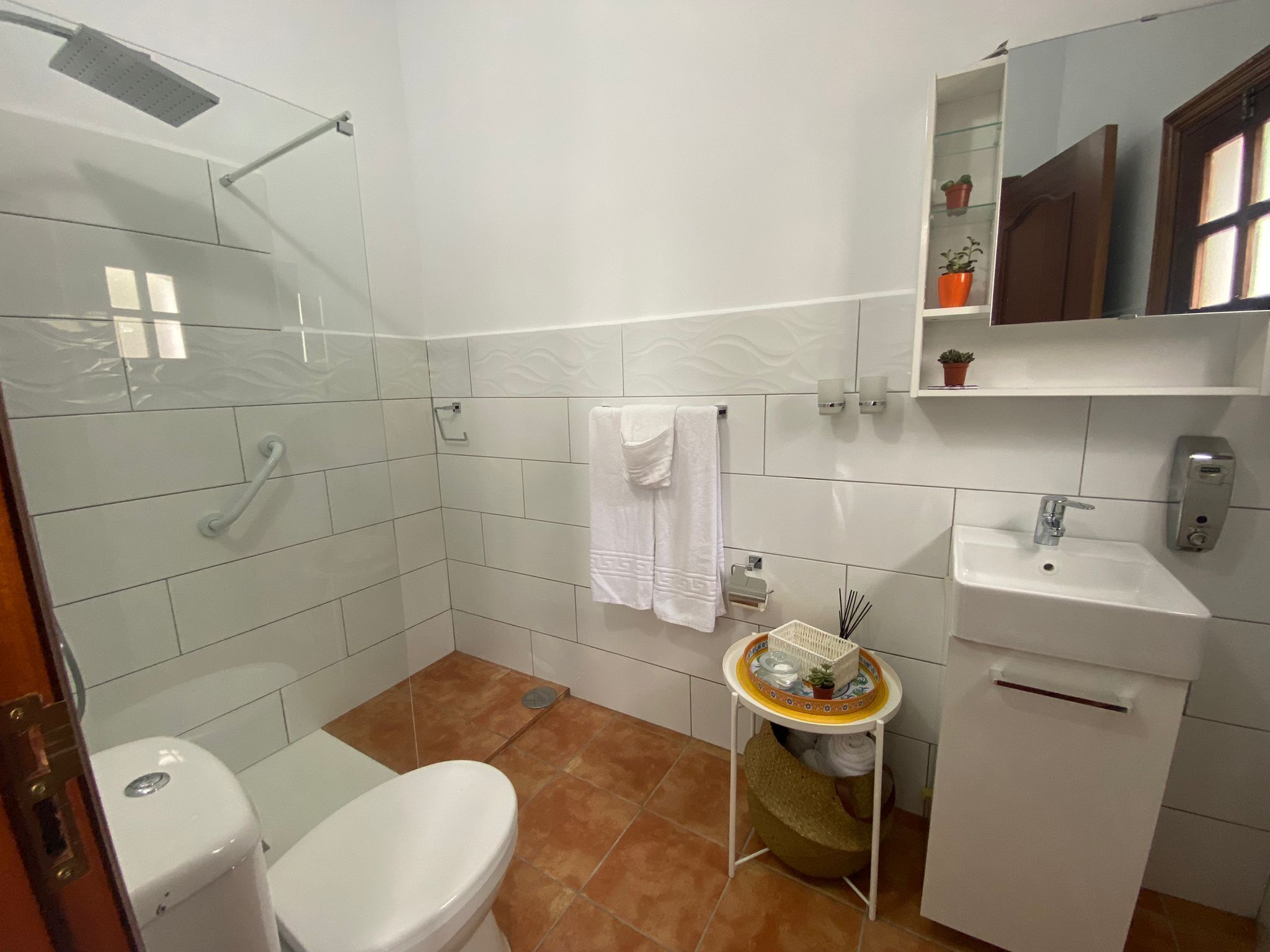 A bathroom with a toilet, sink, and shower.