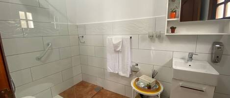 A bathroom with a toilet, sink, and shower.
