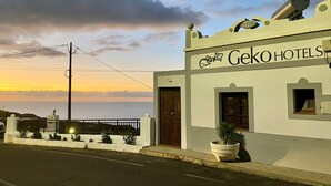 A building with a sign reading "Geko Hotels" and a balcony with a railing.