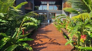 Un edificio moderno con un sendero de madera que conduce a una entrada de cristal.