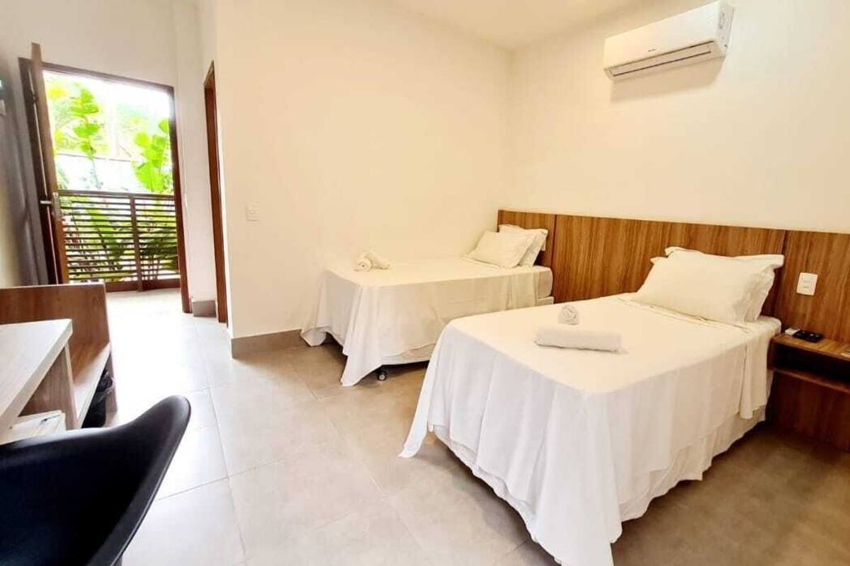 Habitación de hotel con dos camas, un escritorio y una silla.