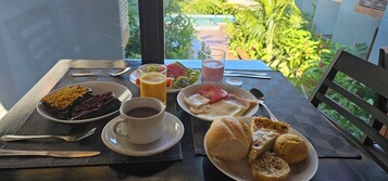 A table with breakfast items including a cup of coffee, a plate with toast, a plate with fruit, and a glass of juice.