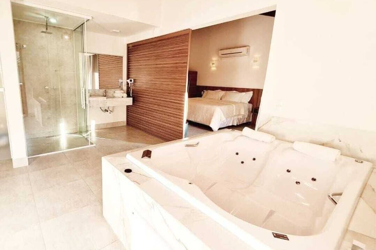 Un baño moderno con una bañera grande, cabina de ducha de vidrio y pared de paneles de madera.