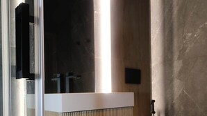 A modern bathroom with a glass shower enclosure, a wooden vanity with a white countertop, and a white toilet. - Hidden GEM- luxurious holiday STUDIO Garibaldi-for couples (Olbia)