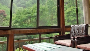 Una habitación con ventanas amplias, una cama y una silla.