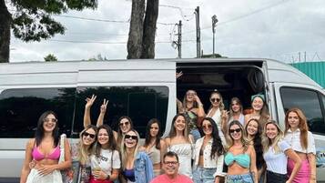 Un grupo de personas posando frente a un vehículo con la puerta abierta.
