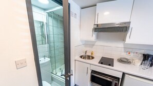 Une cuisine compacte équipée d’un four encastré, d’un évier et d’un four à micro-ondes.