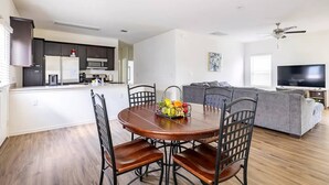A modern living space with a dining area, kitchen, and a gray sofa. - ENTIRE HOME | 3BR WFH Hub | Fast 300 Mbps Wi-Fi | Near SoCo (Austin)
