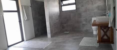 Un baño moderno con ducha, inodoro y lavabo.