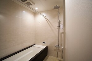 Ein modernes Badezimmer mit Badewanne, Dusche inklusive Handbrause und Bedienfeld.