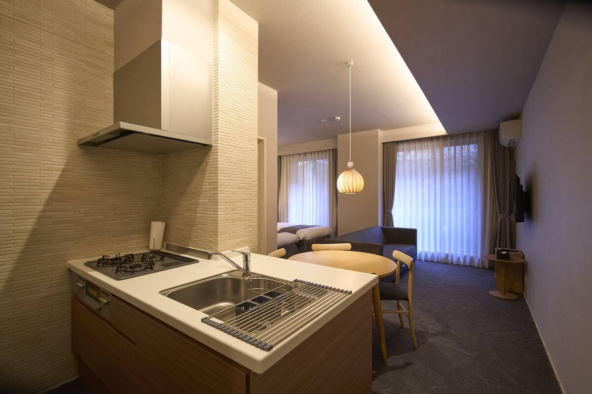 Une chambre d’hôtel moderne dotée d’un coin cuisine, d’une table à manger et d’un canapé.